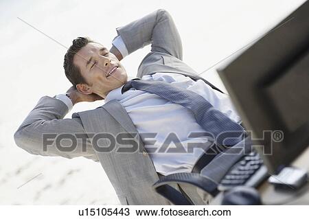 South Africa, Relaxed businessman sitting with laptop in office View Large Photo Image Stock Image - South Africa, Relaxed businessman sitting with laptop in office. Fotosearch