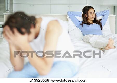 Stock Photo - South Africa, Young couple in bedroom after quarrel. Fotosearch