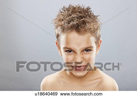 Stock Photo - Studio portrait of angry toothless boy (8-9) . Fotosearch