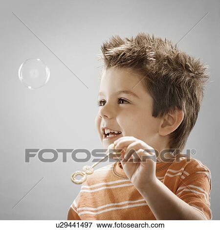Studio portrait of boy (8-9) blowing bubbles View Large Photo Image Stock Photo - Studio portrait of boy (8-9) blowing bubbles. Fotosearch