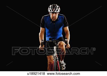 Studio portrait of man cycling View Large Photo Image Stock Photo - Studio portrait of man cycling. Fotosearch