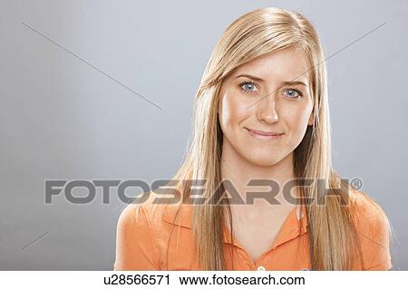 Stock Image - Studio portrait of young woman smiling. Fotosearch