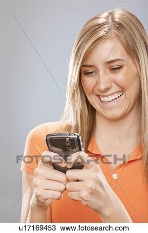 Studio portrait of young woman text messaging View Large Photo Image Stock Image - Studio portrait of young woman text messaging. Fotosearch