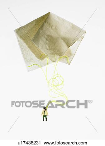 Stock Image - Studio shot of figurine with paper parachute. Fotosearch