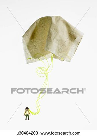 Stock Image - Studio shot of figurine with paper parachute. Fotosearch