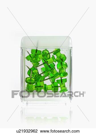 Stock Image - Studio shot of green thumbtacks in glass cube. Fotosearch