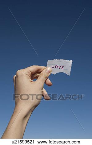 USA, Arizona, Winslow, Human hand holding love note against blue sky View Large Photo Image Stock Image - USA, Arizona, Winslow, Human hand holding love note against blue sky. Fotosearch