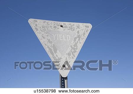 Stock Photo - USA, Arizona, Winslow, Old yield sign against blue sky. Fotosearch