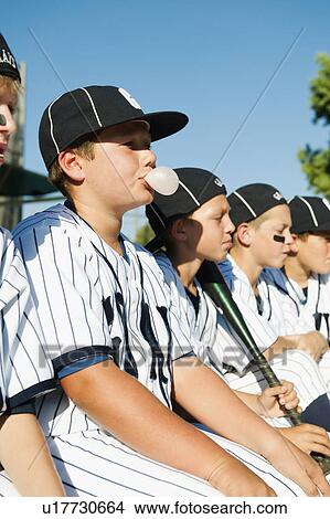 Picture - USA, California, Ladera Ranch, Boys (10-11) from little league sitting on dugout. Fotosearch