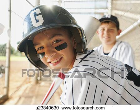 Stock Image - USA, California, Ladera Ranch, boys (10-11) from little league baseball team on dugout. Fotosearch