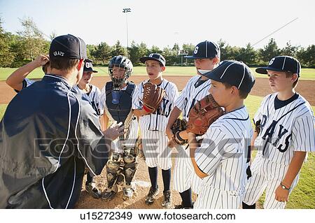 Stock Photo - USA, California, Ladera Ranch, coach training little league baseball team (10-11). Fotosearch