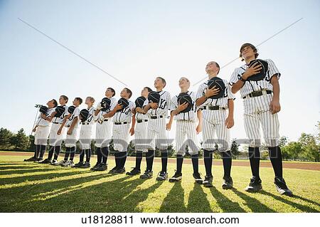 Stock Image - USA, California, Ladera Ranch, little league players (aged 10-11) on field. Fotosearch