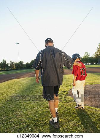 USA, California, Ladera Ranch, man and boy (10-11) walking on baseball field View Large Photo Image Picture - USA, California, Ladera Ranch, man and boy (10-11) walking on baseball field. Fotosearch