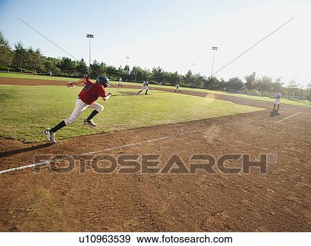 Stock Photo - USA, California, little league baseball team (10-11) during baseball match. Fotosearch