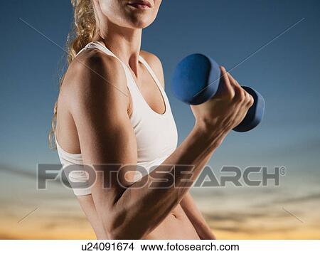 Picture - USA, California, Los Angeles, woman exercising with dumbbells. Fotosearch