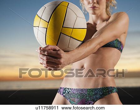 Stock Image - USA, California, Los Angeles, woman playing beach volleyball. Fotosearch