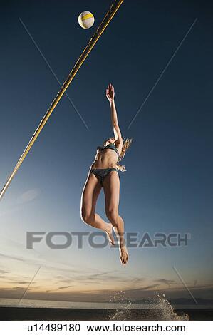 Stock Image - USA, California, Los Angeles, woman playing beach volleyball. Fotosearch