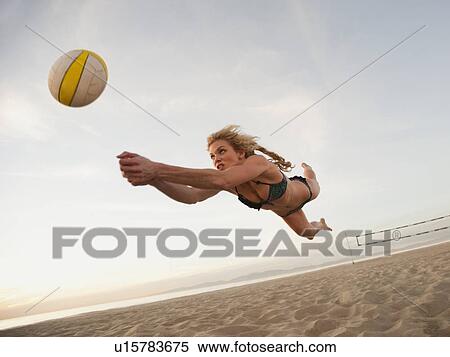 Stock Photography - USA, California, Los Angeles, woman playing beach volleyball. Fotosearch