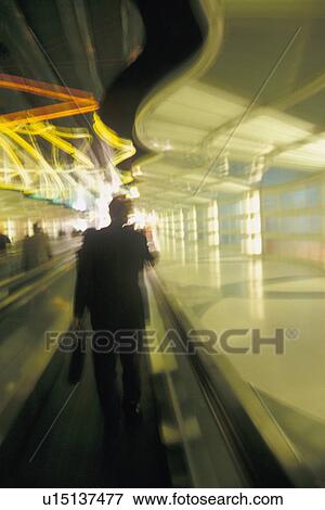 Stock Photo - USA, Colorado, Businessman walking through airport, blurred motion. Fotosearch