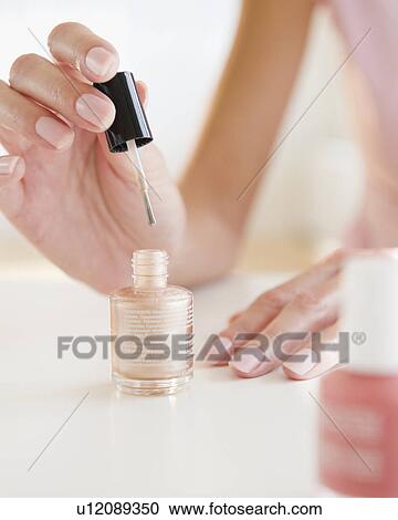 Stock Image - USA, New Jersey, Jersey City, Close-up view of woman painting fingernails. Fotosearch