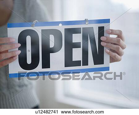 USA, New Jersey, Jersey City, Close-up view of woman holding open sign View Large Photo Image Stock Image - USA, New Jersey, Jersey City, Close-up view of woman holding open sign. Fotosearch