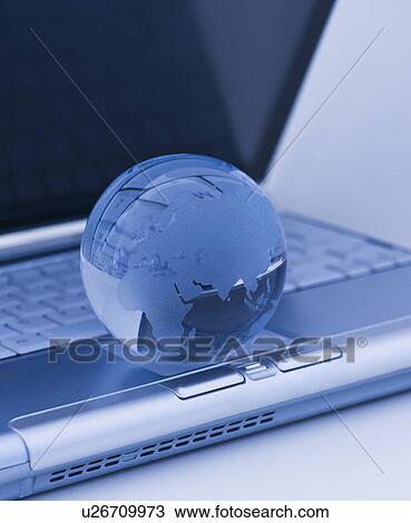 Stock Image - USA, New Jersey, Jersey City, Close-up view of blue laptop and globe. Fotosearch