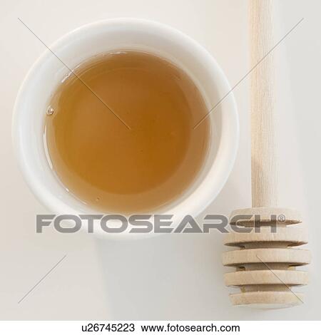 Stock Image - USA, New Jersey, Jersey City, Close-up view of honey and honey spoon. Fotosearch