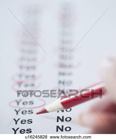 Stock Photo - USA, New Jersey, Jersey City, Close-up view of woman's hand filling in form. Fotosearch