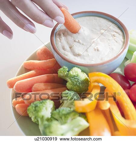 USA, New Jersey, Jersey City, Close-up view of woman hand putting baby carrot into dip View Large Photo Image Stock Photo - USA, New Jersey, Jersey City, Close-up view of woman hand putting baby carrot into dip. Fotosearch