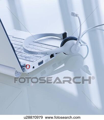Stock Photo - USA, New Jersey, Jersey City, Close-up view of open laptop and headset . Fotosearch