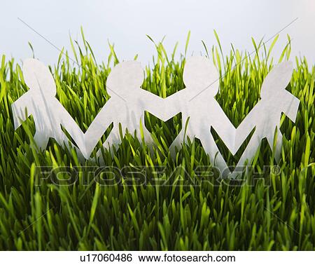 Stock Photograph - USA, New Jersey, Jersey City, Close-up view of white paper figurines in grass. Fotosearch