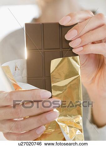 Stock Photograph - USA, New Jersey, Jersey City, Close-up of woman holding chocolate bar. Fotosearch