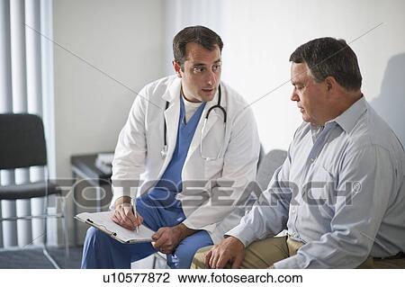 Stock Image - USA, New Jersey, Jersey City, Doctor discussing medical results with male patient in hospital. Fotosearch