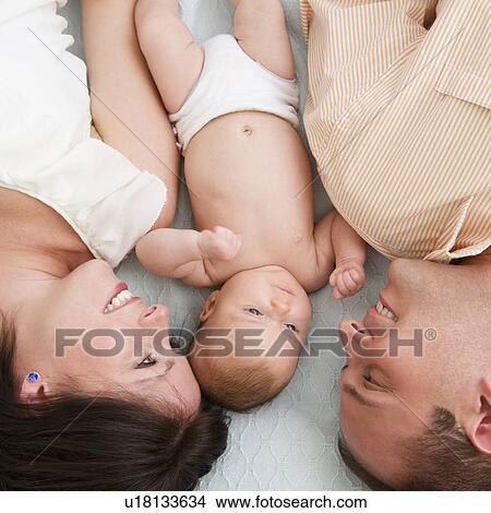 USA, New Jersey, Jersey City, Family with baby daughter (2-5 months) laying upside down View Large Photo Image Picture - USA, New Jersey, Jersey City, Family with baby daughter (2-5 months) laying upside down. Fotosearch