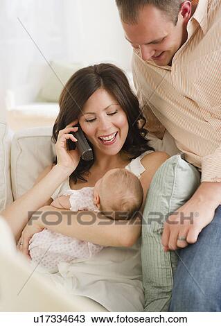 USA, New Jersey, Jersey City, Father watching baby daughter (2-5 months) as mother is using telephone View Large Photo Image Stock Image - USA, New Jersey, Jersey City, Father watching baby daughter (2-5 months) as mother is using telephone. Fotosearch