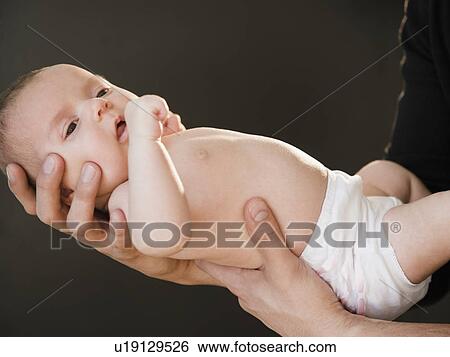 Stock Photograph - USA, New Jersey, Jersey City, Father holding baby girl (2-5 months). Fotosearch
