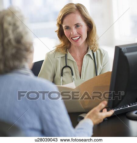 USA, New Jersey, Jersey City, Female doctor discussing medical record with patient in office View Large Photo Image Stock Image - USA, New Jersey, Jersey City, Female doctor discussing medical record with patient in office. Fotosearch