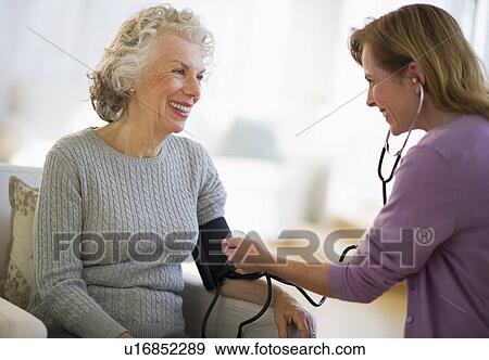 USA, New Jersey, Jersey City, Female nurse checking patients blood pressure View Large Photo Image Stock Photo - USA, New Jersey, Jersey City, Female nurse checking patients blood pressure. Fotosearch