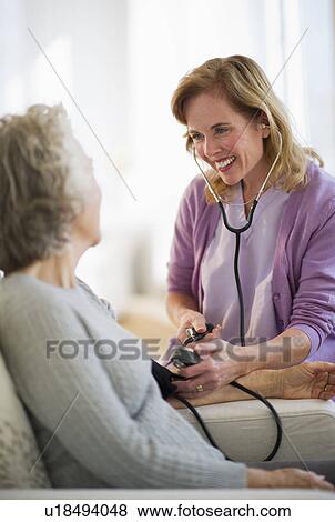 USA, New Jersey, Jersey City, Female nurse checking patients blood pressure View Large Photo Image Stock Photo - USA, New Jersey, Jersey City, Female nurse checking patients blood pressure. Fotosearch