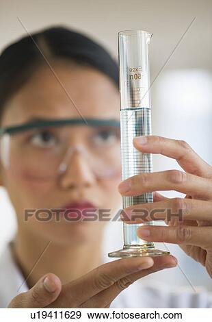 Stock Photo - USA, New Jersey, Jersey City, Female scientist holding chemical test tube. Fotosearch