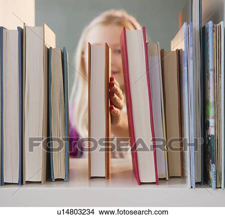 USA, New Jersey, Jersey City, Girl (8-9) arranging book View Large Photo Image Picture - USA, New Jersey, Jersey City, Girl (8-9) arranging book. Fotosearch