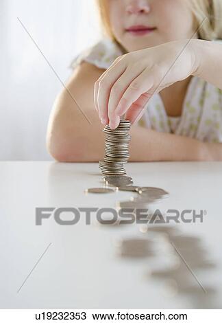 Stock Image - USA, New Jersey, Jersey City, Girl (8-9) playing with coins. Fotosearch