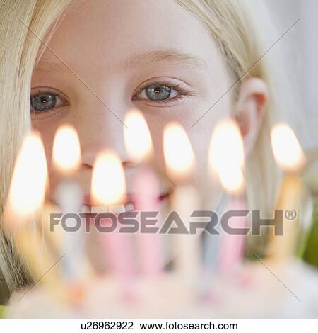 Stock Image - USA, New Jersey, Jersey City, Girl (8-9) in front of birthday cake. Fotosearch