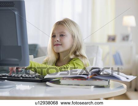 Stock Photo - USA, New Jersey, Jersey City, Girl (8-9) sitting in front of computer. Fotosearch