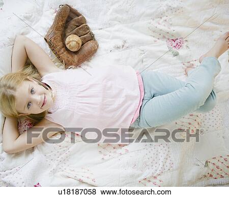 USA, New Jersey, Jersey City, Girl (8-9) laying beside baseball glove and ball View Large Photo Image Stock Photo - USA, New Jersey, Jersey City, Girl (8-9) laying beside baseball glove and ball. Fotosearch