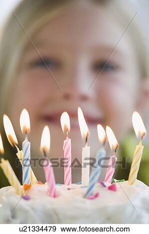 Stock Photo - USA, New Jersey, Jersey City, Girl (8-9) in front of birthday cake. Fotosearch