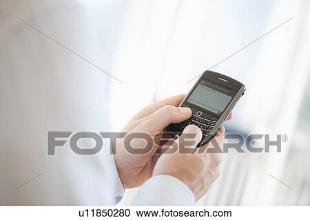 Stock Image - USA, New Jersey, Jersey City, Man holding mobile phone . Fotosearch