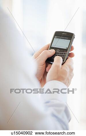 Stock Image - USA, New Jersey, Jersey City, Man holding mobile phone . Fotosearch