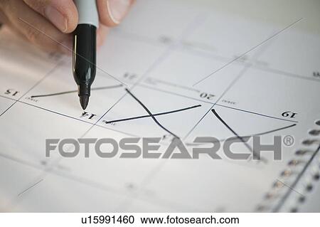 Stock Image - USA, New Jersey, Jersey City, Man writing on calendar. Fotosearch