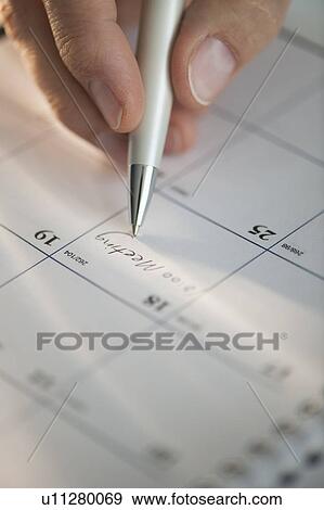 Stock Photo - USA, New Jersey, Jersey City, Man writing on calendar. Fotosearch